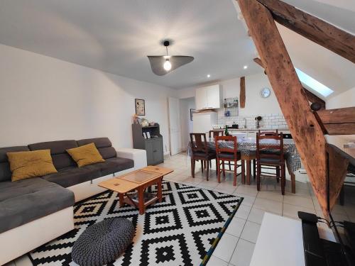 a living room with a couch and a table at Appartement au coeur de la Suisse normande in Thury-Harcourt