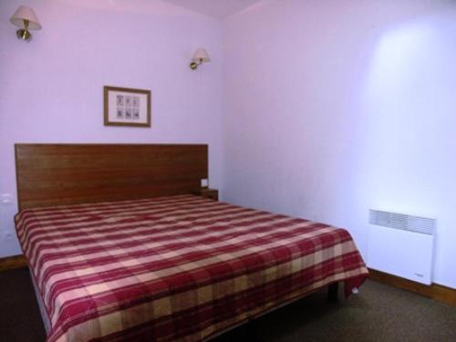 une chambre avec un lit avec une couverture rayée dans l'établissement Chalet D'orcieres - 2 Pièces duplex 7/8 personnes MAE-2772, à Orcières