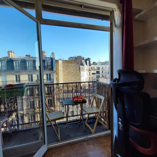 un balcon avec une table et des chaises et une vue dans l'établissement Studio COSY et SPACIEUX AVEC EMPLACEMENT IDEAL, à Paris