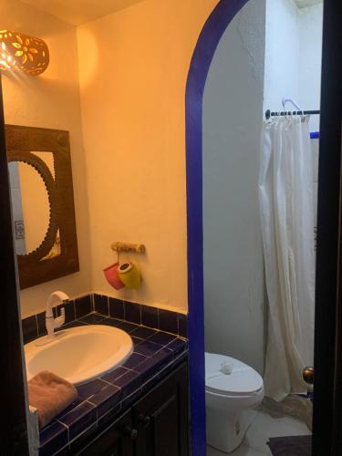 a bathroom with a sink and a toilet and a mirror at Casa CARIBE Cancun in Cancún