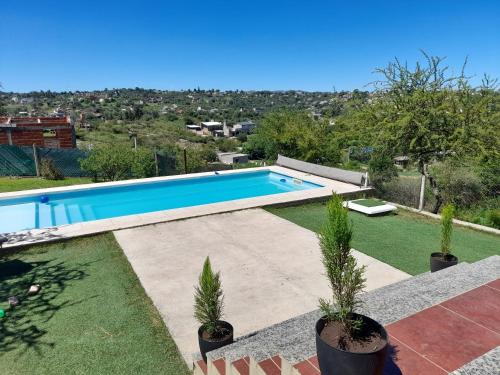 a swimming pool in a yard with potted plants at Estancia Borke - Carlos Paz in Estancia Vieja