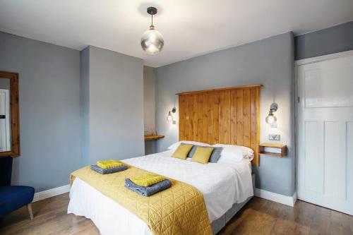Stylish and cosy cottage in the heart of Yorkshire في ليدز: غرفة نوم بسرير كبير مع بطانية صفراء