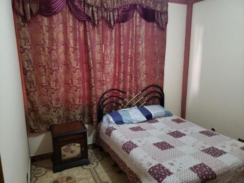 a bedroom with a bed and a red curtain at Departamento Acogedor _ EDIF. MAIRANA in Cochabamba