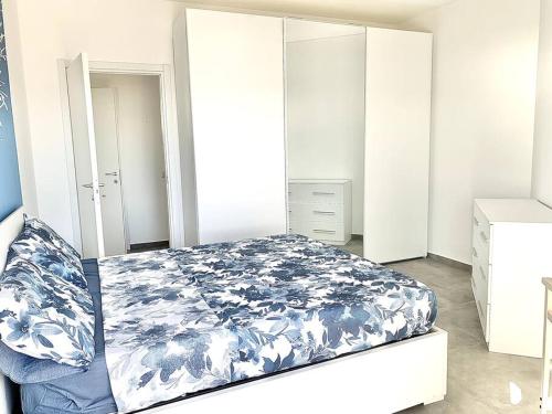 um quarto com uma cama com uma colcha azul e branca em [10 min. da Sanremo] Appartamento Vista Mare em Taggia