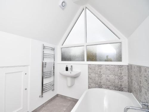 a white bathroom with a sink and a tub and a window at 3 bed in Hamsterley 81503 in Evenwood