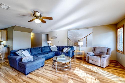 a living room with a blue couch and two chairs at Tigers Den - Lower in Arkdale
