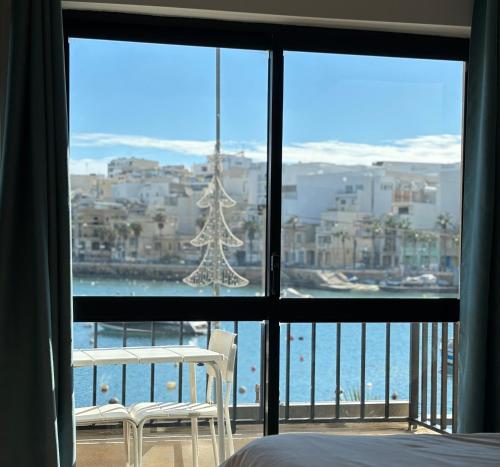 a bedroom with a large window with a christmas tree at Sunrise Creek in Marsaskala