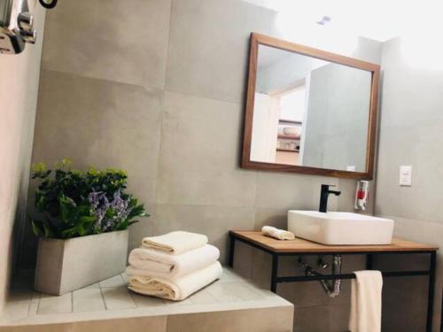 a bathroom with a sink and a mirror and towels at Urban Chapalita in Guadalajara
