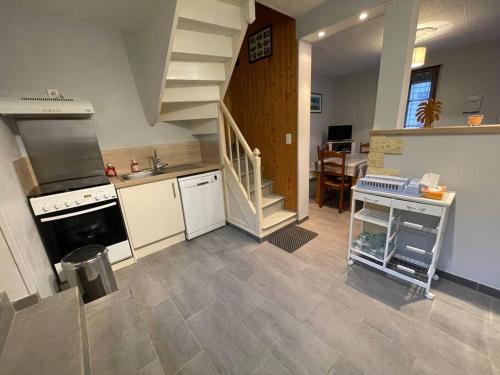 d'une cuisine avec cuisinière et évier et d'un escalier. dans l'établissement LE ZEPHYR maison de pecheur Etretat, à Étretat