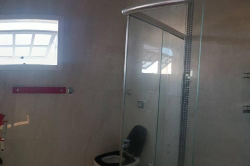 a glass shower in a bathroom with a toilet at Sobrado Completo Belíssima in Pelotas