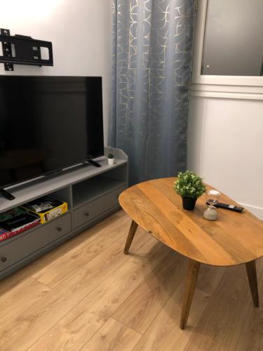 a living room with a coffee table and a television at Magnifique appartement pouvant accueillir 6 personnes à 20 minutes de paris in Antony
