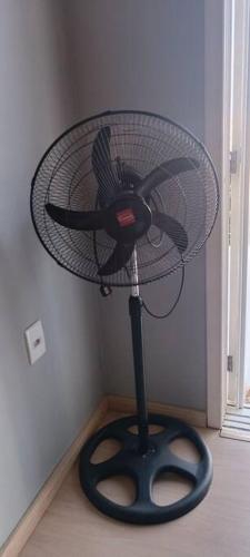 a fan sitting on a floor in a room at Sobrado Completo Belíssima in Pelotas