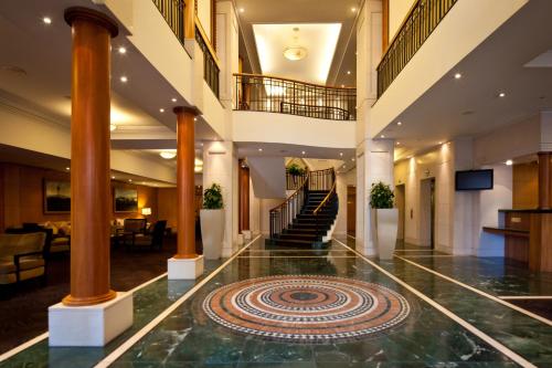 a large room with a large staircase leading to a lobby at The Sebel Quay West Auckland in Auckland