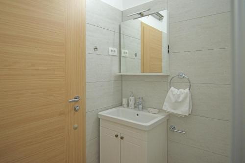W łazience znajduje się umywalka i lustro. w obiekcie Apartmani Tomica w mieście Jesenice
