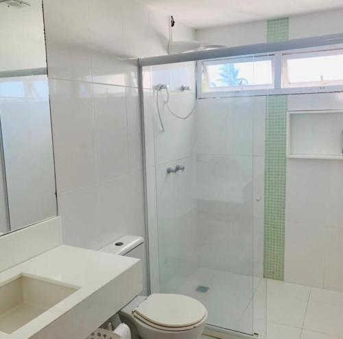 een witte badkamer met een douche en een toilet bij Casa Villas in Lauro de Freitas