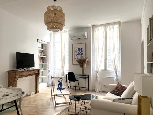 un salon avec un canapé blanc et une cheminée dans l'établissement Le refuge des Papes *clim *hypercentre, à Avignon