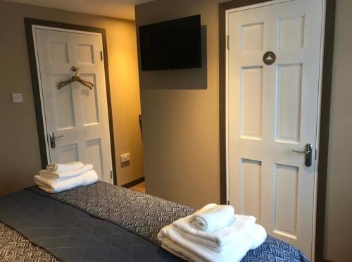 um quarto com uma cama com toalhas brancas em Central House em Shillelagh