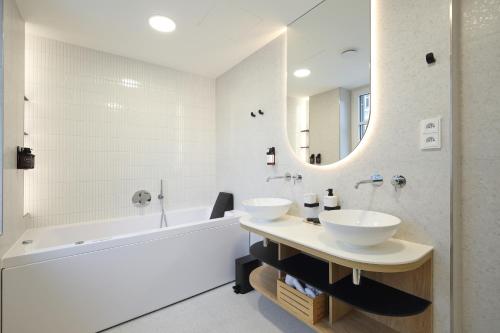 y baño con 2 lavabos, bañera y espejo. en Apartmány Vila Terasy en Liberec
