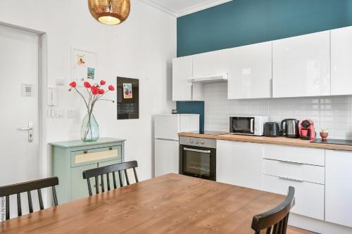 une cuisine avec des armoires blanches et une table avec des chaises dans l'établissement La Loge Vieux-Port, à Marseille