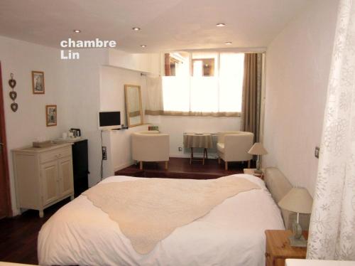 - une chambre avec un lit blanc, une table et des chaises dans l'établissement Les Filateries Chambre Lin, à Annecy