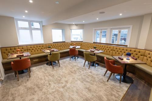 a restaurant with tables and chairs and windows at The Resolution Hotel in Whitby