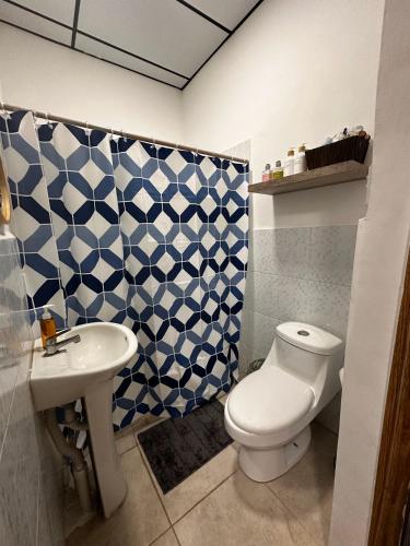 a bathroom with a white toilet and a sink at Casa Mia in San Miguel