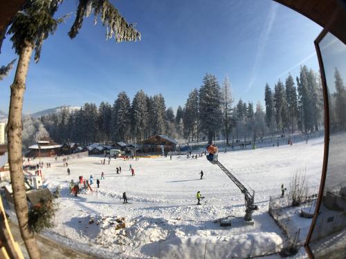 a group of people on a ski slope in the snow at Pensiunea "Casa Frasin" in Vatra Dornei