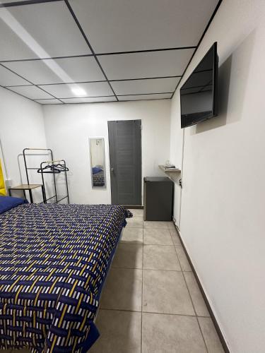 Schlafzimmer mit einem Bett und einem Flachbild-TV in der Unterkunft Casa Mia in San Miguel