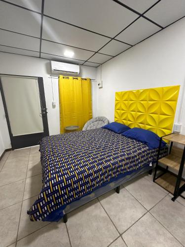 una camera con letto e testiera gialla di Casa Mia a San Miguel