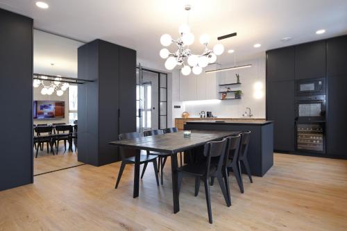 cocina y comedor con mesa negra y sillas en Apartmány Vila Terasy, en Liberec