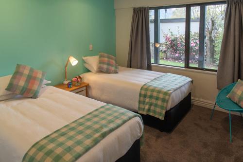 a hotel room with two beds and a window at Pip's Lakeview Retreat in Wanaka
