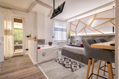 um quarto com uma cama, uma banheira e uma mesa em saige holidays em Alghero