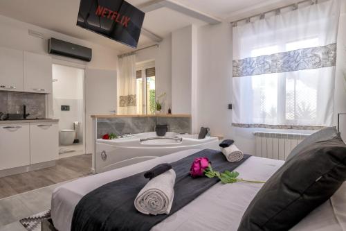 a bedroom with a large bed and a bath tub at saige holidays in Alghero