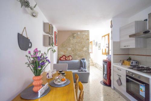 una cocina y comedor con una mesa con flores. en La Casita en Brendola