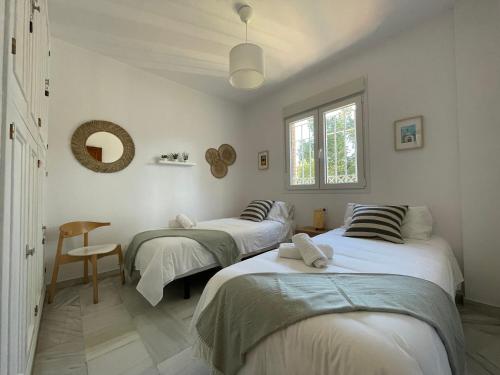 Duas camas num quarto com paredes brancas em El Jardin de la Palmera em Sevilha