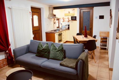 ein Wohnzimmer mit einem blauen Sofa und einer Küche in der Unterkunft Maisonette in Nus