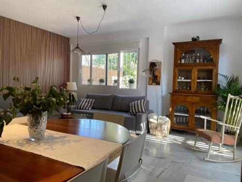 uma sala de estar com uma mesa e um sofá em El Jardin de la Palmera em Sevilha