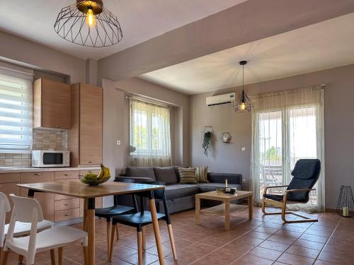 a kitchen and living room with a couch and a table at MyseA VillasNikiti in Nikiti