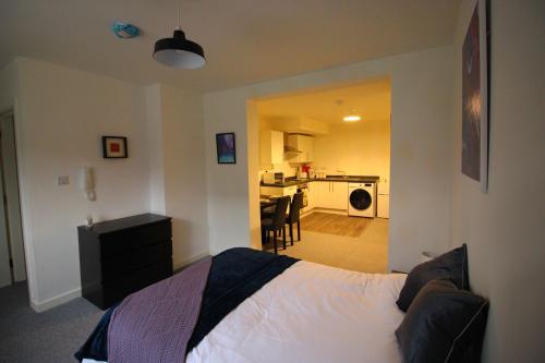 ein Schlafzimmer mit einem Bett und ein Wohnzimmer mit einer Küche in der Unterkunft Convenience & Comfort - 1Bed Apt in Heywood in Heywood