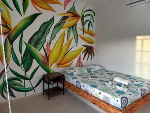 プエルト・トリウンフォにあるfinca campestre las heliconiasの壁に絵画が描かれたベッド付きの部屋