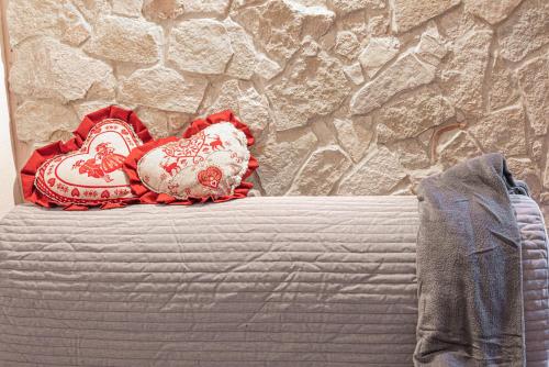 a pile of pillows on a bed with a stone wall at La Casita in Brendola