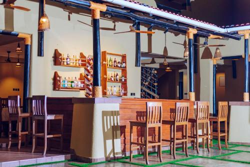 un ristorante con sedie in legno e un bar di The Maridadi Hotel a Moshi