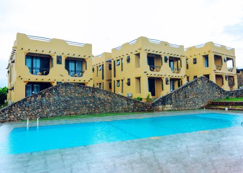 - un grand bâtiment avec une piscine en face dans l'établissement The Maridadi Hotel, à Moshi