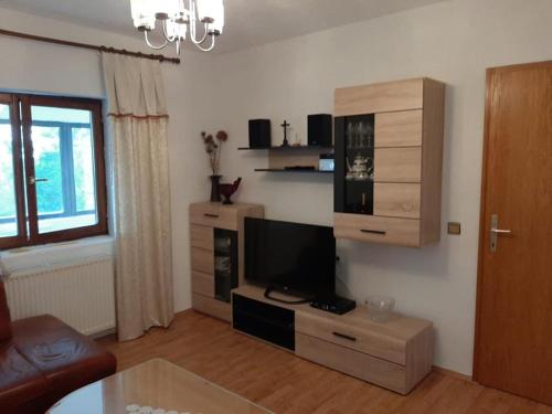 ein Wohnzimmer mit einem Entertainment-Center und einem Flachbild-TV in der Unterkunft Ivković Residence in Livno