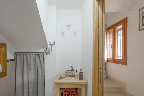 a bathroom with a shower curtain and a table at La Casita in Brendola