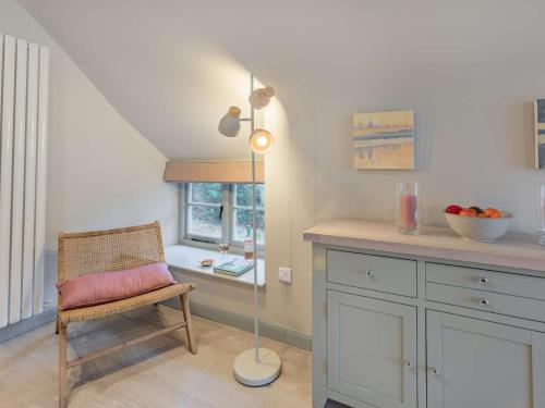 Habitación con silla, lámpara de pie y mesa. en 2 Bed in Bideford 86404, en Bideford