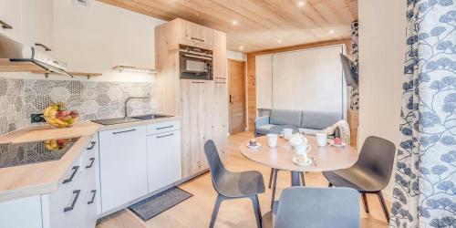 a kitchen with a table and chairs in a room at Résidence Le Centre - 2 Pièces pour 4 Personnes MAE-3338 in Champagny-en-Vanoise