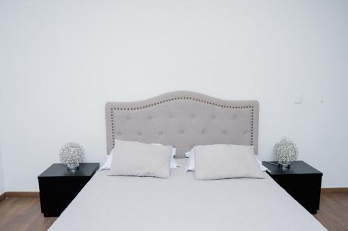 a bedroom with a white bed with two night stands at Villa Santiago in Praia