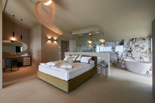 1 dormitorio con 1 cama grande y bañera en Loft experience Amore & Psyche a Carobais 7, en Roncola
