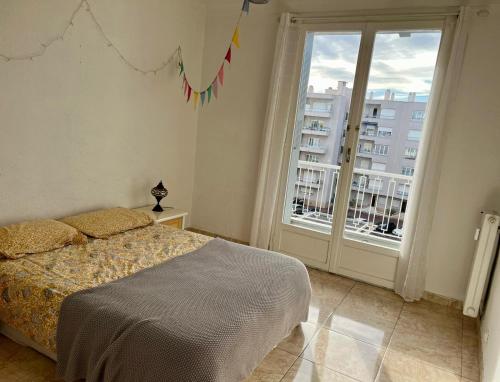 une chambre avec un lit et une grande fenêtre dans l'établissement Appartement à 50 mètres de la plage, à Cagnes-sur-Mer